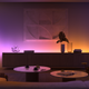 A photo of a room lit up with different Philips Hue smart lights, in purple and yellow arrays